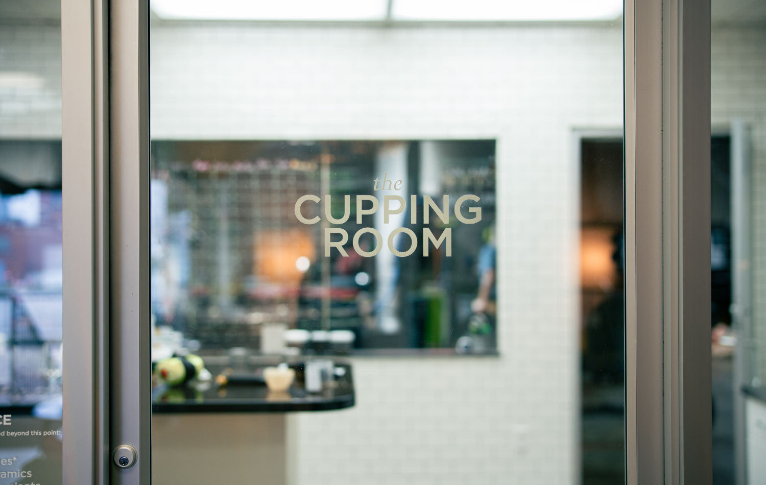 The glass door of the Cupping Room in the Kaldi's Coffee Roastery