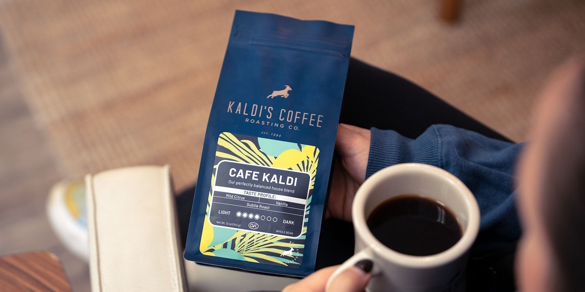 Holding a 12 ounce bag of Cafe Kaldi coffee blend
