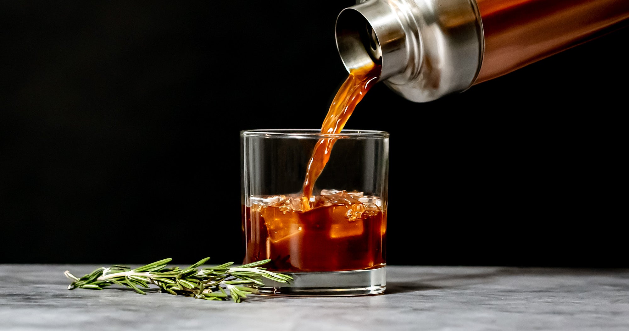 The Brown Sugar Rosemary Old Fashioned is pour from a cocktail shaker