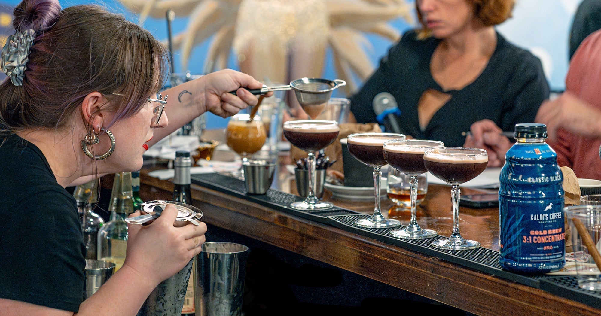 Amanda strains her coffee cocktail beside our Cold Brew Concentrate