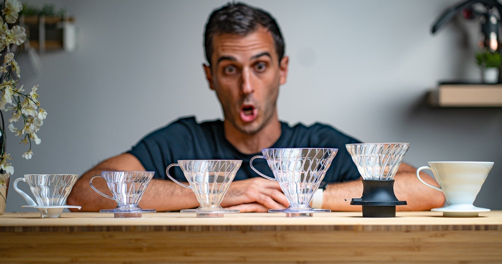 Rob in front of several V60 coffee brewers - glass, plastic, ceramic, and the Hario Switch