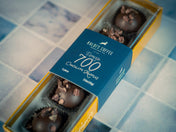 Box of chocolates with a blue label on a tiled floor