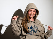 Model smiling in Kaldi's Coffee hooded sweatshirt