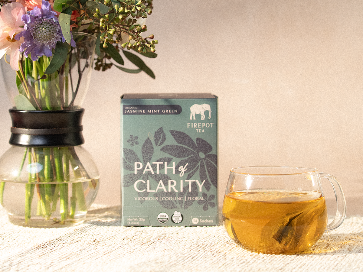 box of path of clarity and a glass mug of yellow tea