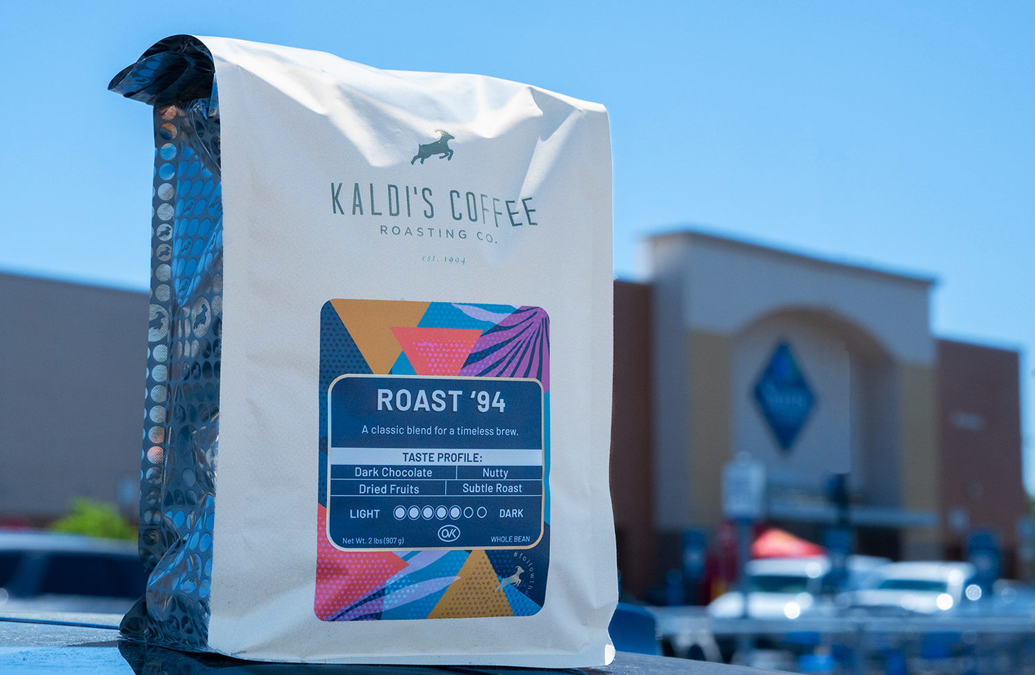 Kaldi's Coffee bag with a colorful label on a blurred outdoor background